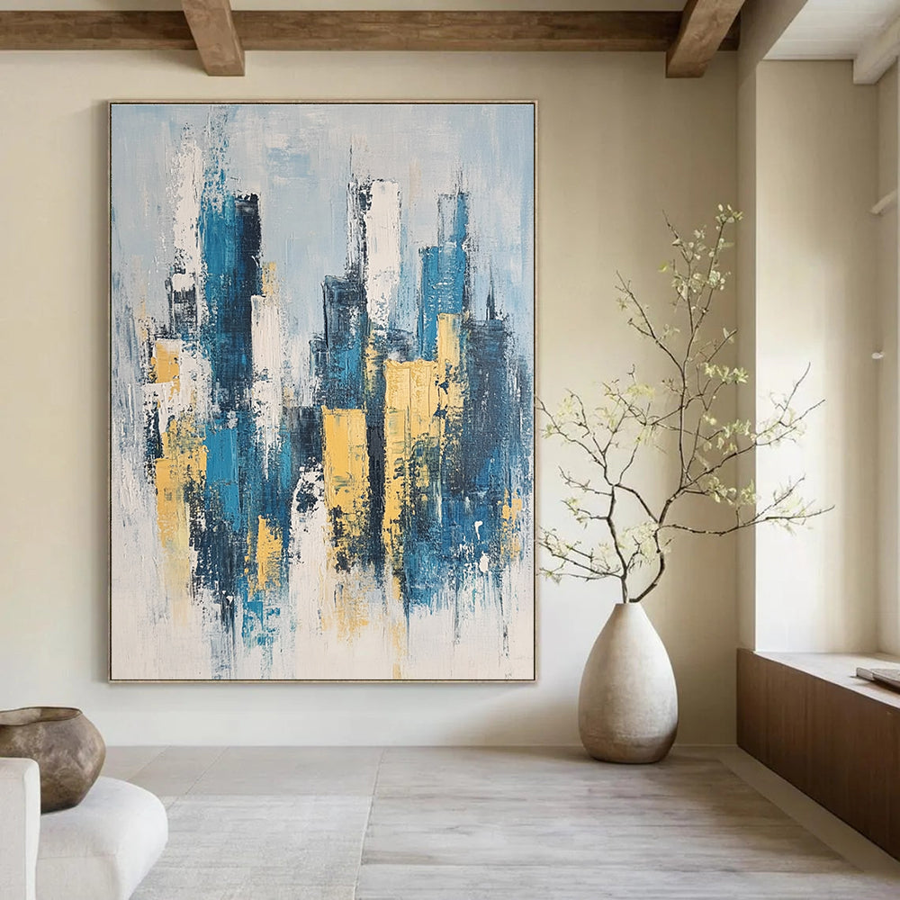 Large abstract painting featuring a modern cityscape in neutral blue and gray tones with yellow accents inspired by impressionist style.STSC1358
