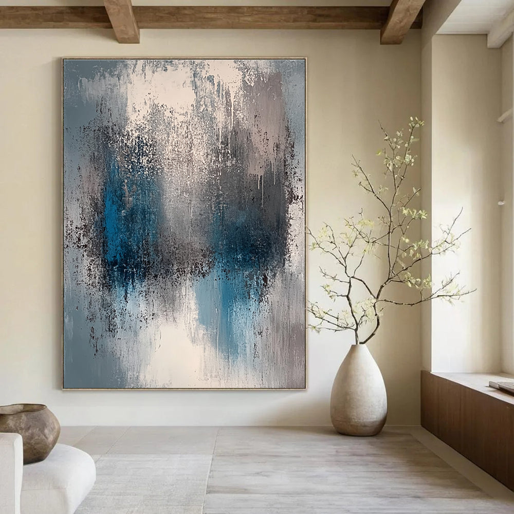 A large abstract painting featuring a faded gray and blue color palette with soft lighting and neutral tones.STSC577