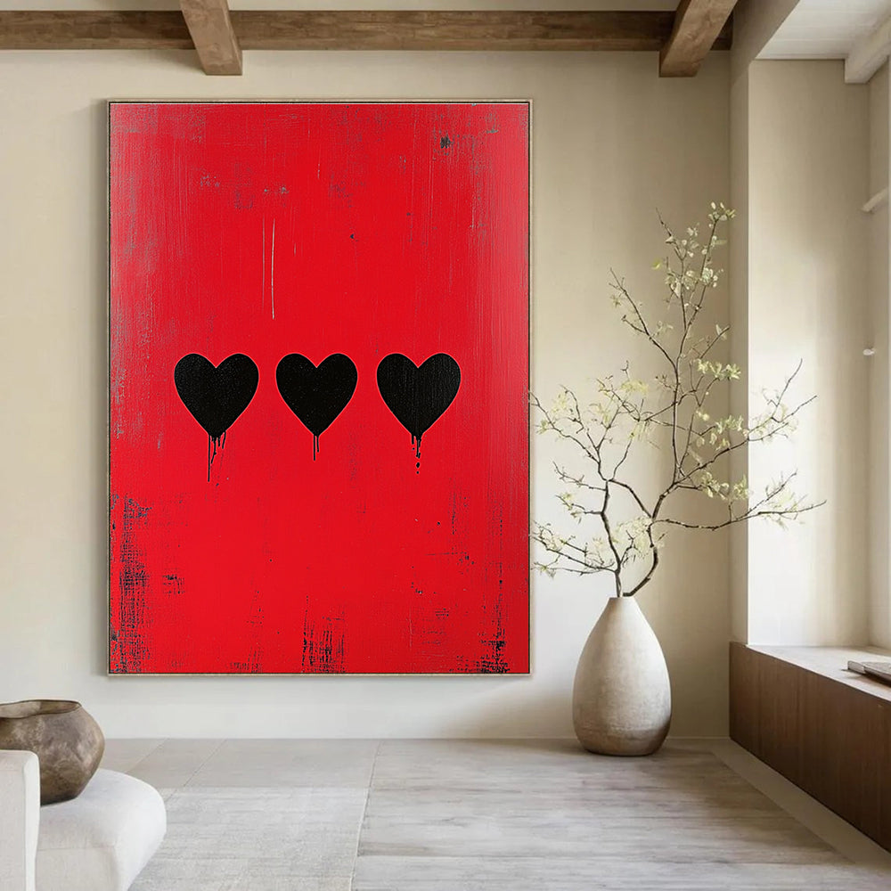 Large abstract painting with a striking red background featuring three bold black hearts in a style reminiscent of Banksy.STSC1164