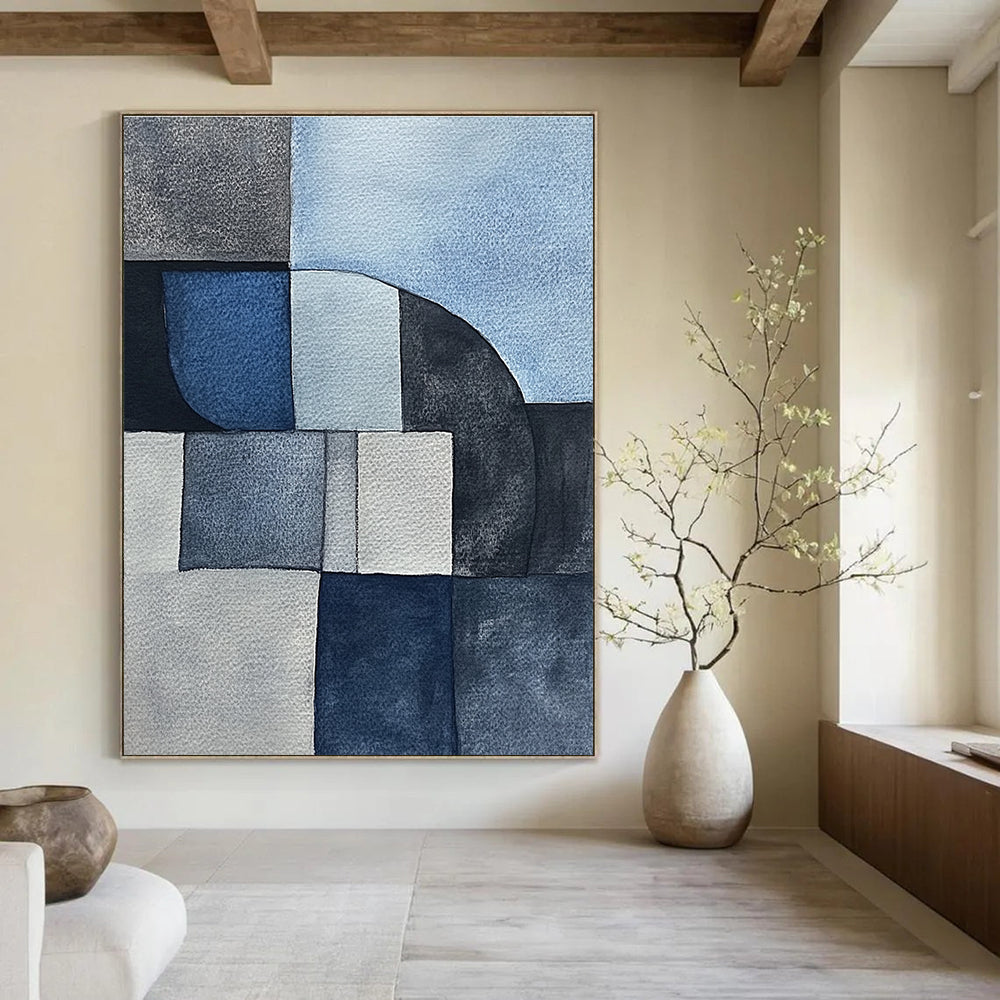 Large abstract painting features minimalistic gray-blue watercolor cubist shapes depicting sandstone rocks in a serene desert landscape.STSC240