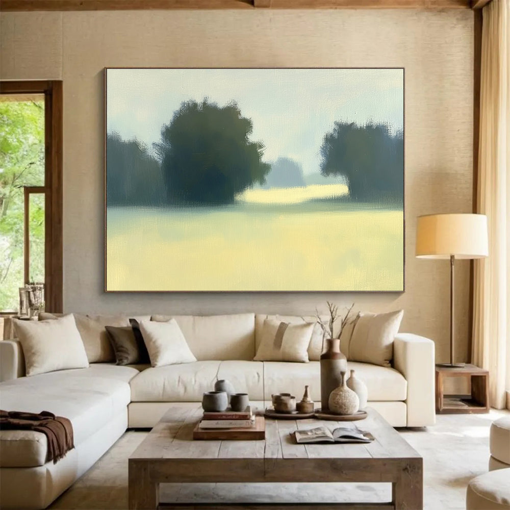 A large abstract painting featuring impasto technique with soft hues of green and yellow depicting a hazy field with distant trees.SC498