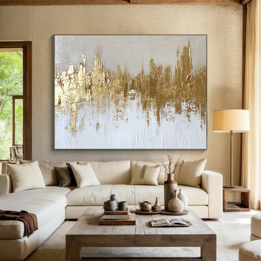 Large abstract painting of a gold and white cityscape with textured canvas and gold foil accents on a neutral background.SC173