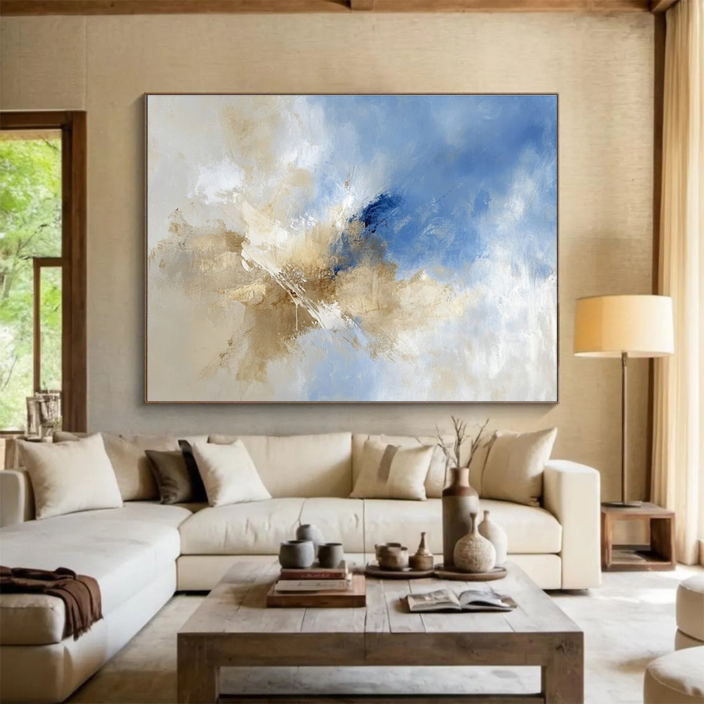 Large abstract painting featuring blue and beige hues with clouds in the sky, blending earthy tones of brown for a serene atmosphere.SC020