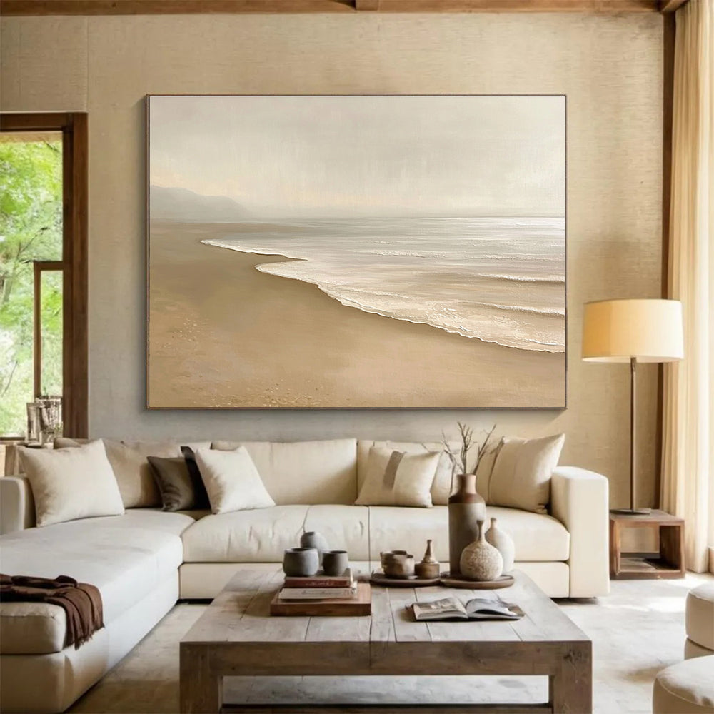 Large abstract painting featuring a serene beach with beige and white tones capturing gentle waves and soft sand in a tranquil setting.SC424
