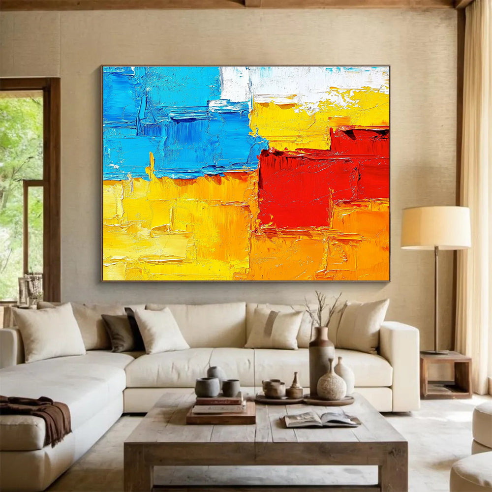 Large abstract painting featuring textured impasto brushstrokes in warm sunset tones of orange red yellow and blue.SC261