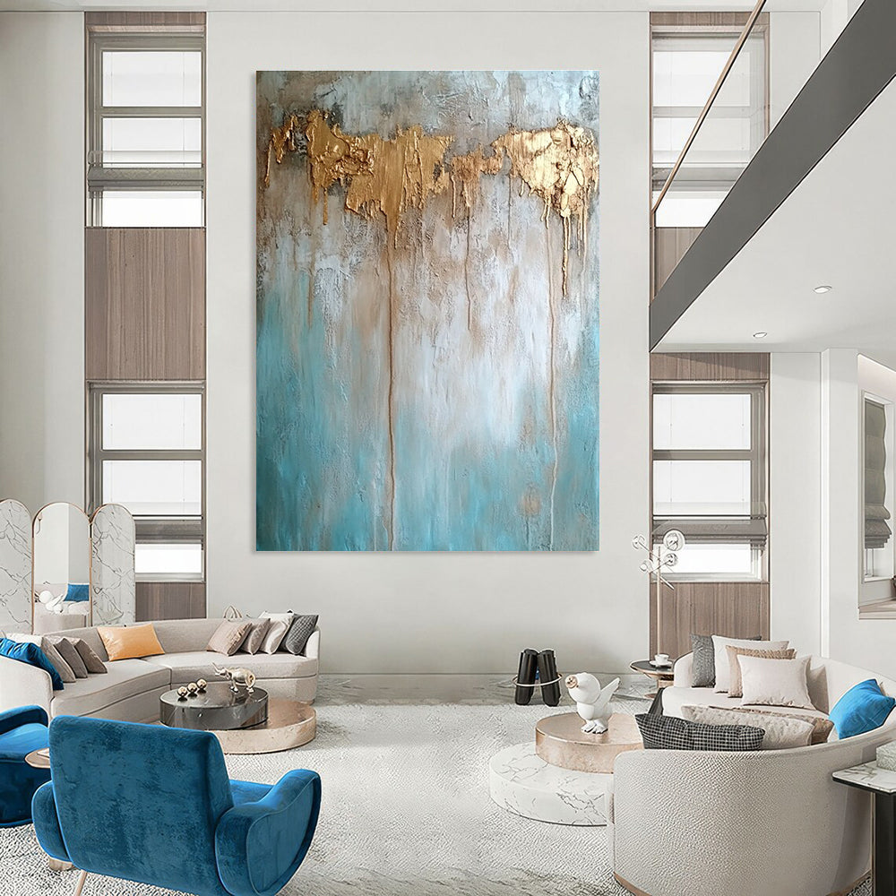 Large abstract painting with texture in neutral tones featuring light blue brown and gold hues highlighting water damage elements against a concrete wood background.STSC136