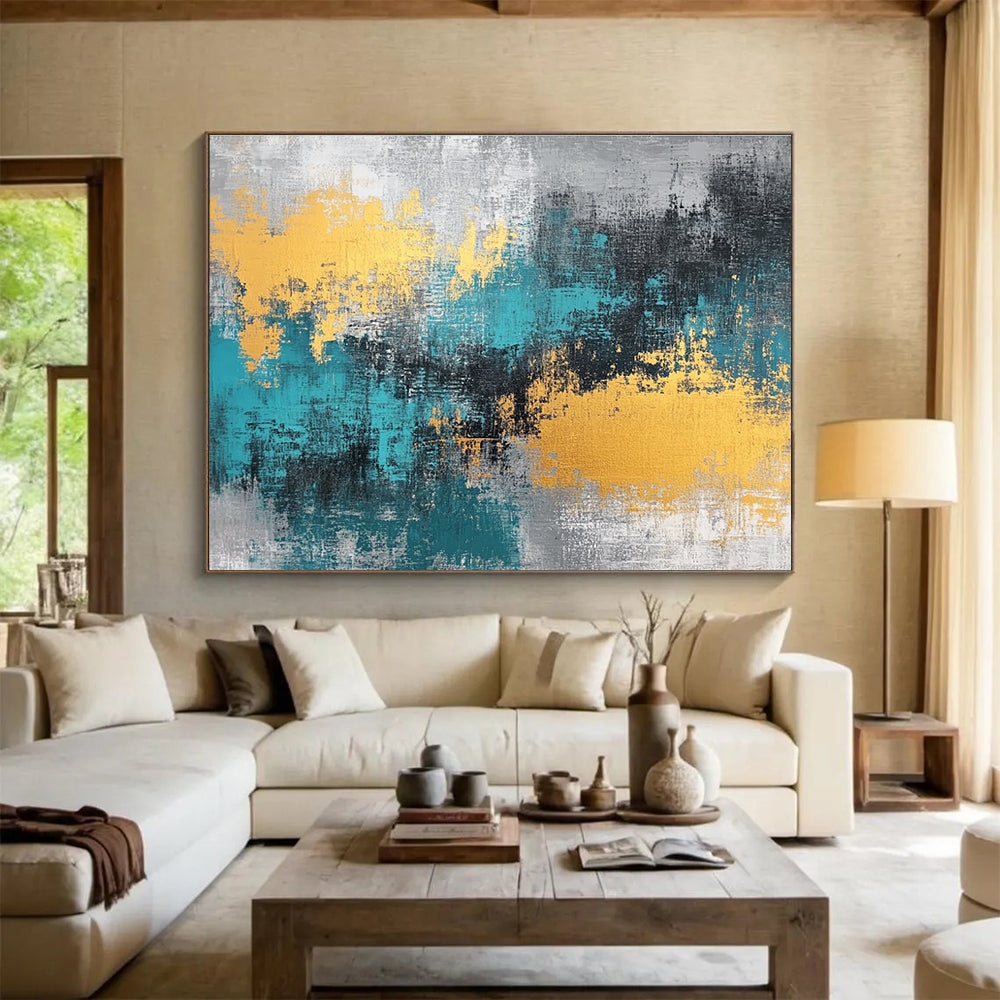 Large abstract painting featuring teal, grey, and gold hues that add a vibrant touch to any space.SC260