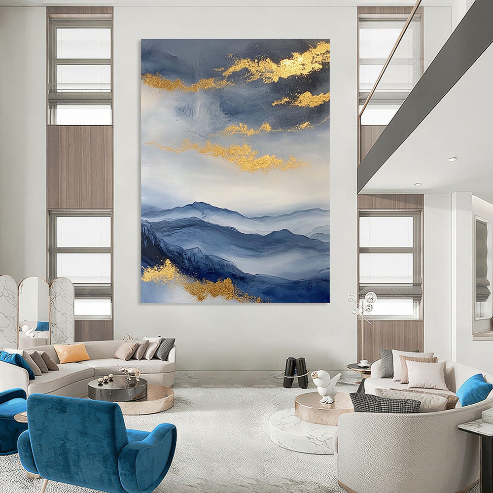 Large abstract painting featuring a beautiful sky mountains and clouds in blue and gray with gold foil accents.STSC279