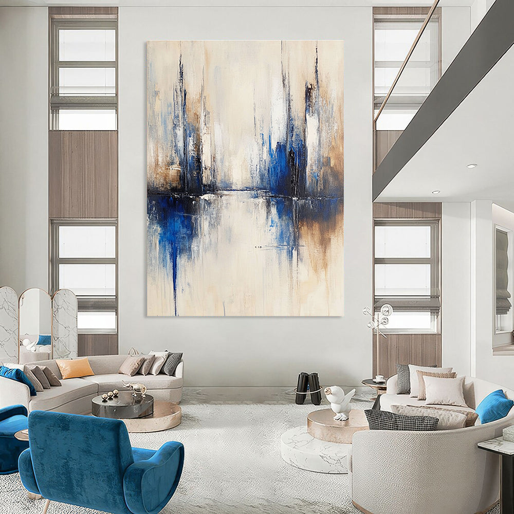 Large abstract painting of a city with muted white and blue tones on a beige background featuring blurred brush strokes reflecting in water.STSC134