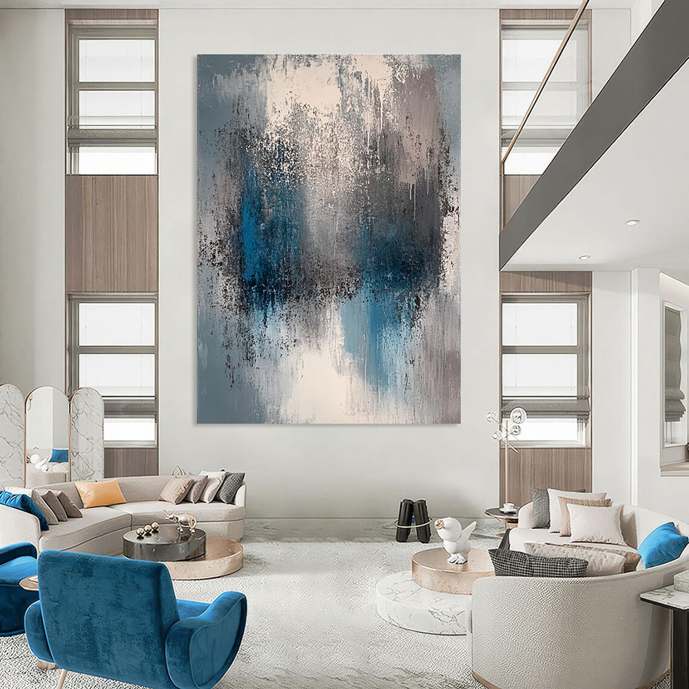 A large abstract painting featuring a faded gray and blue color palette with soft lighting and neutral tones.STSC577