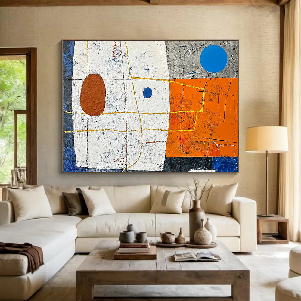A large abstract painting featuring white squares orange and blue shapes yellow lines a small brown oval and a blue dot on a vibrant orange and dark grey background.SC376
