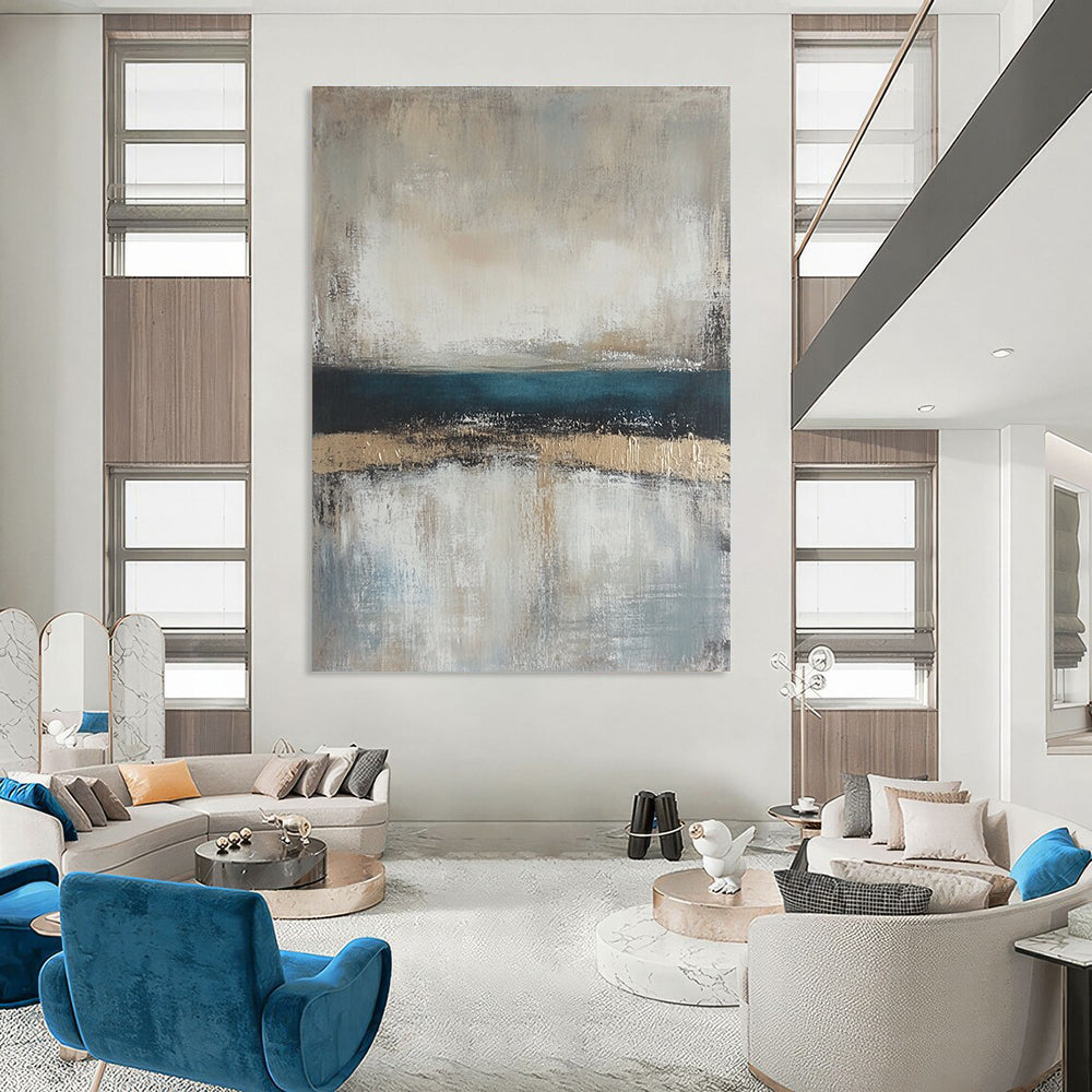 Large abstract painting featuring neutral colors and soft tones of beige gray and blue with a serene horizon line.STSC462