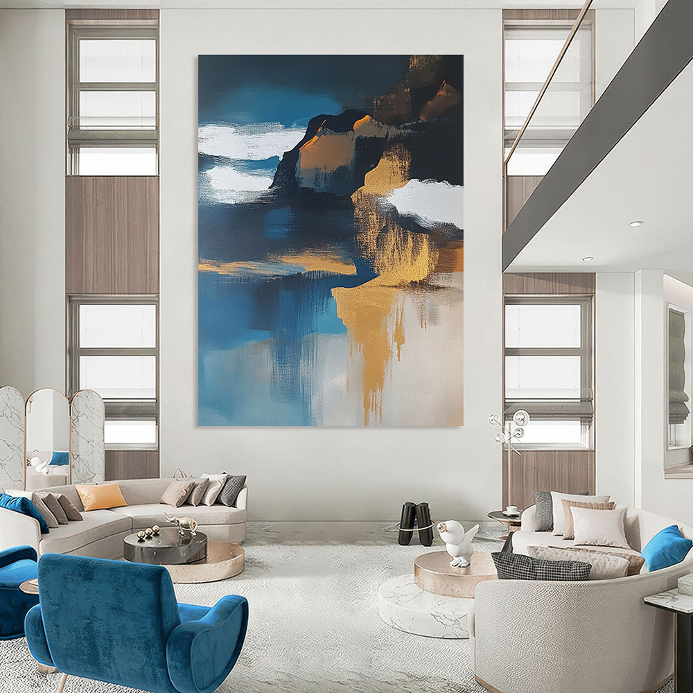 Large abstract painting of an island featuring navy blue water white clouds brown sand and gold leafing exuding a sense of calmness.STSC651