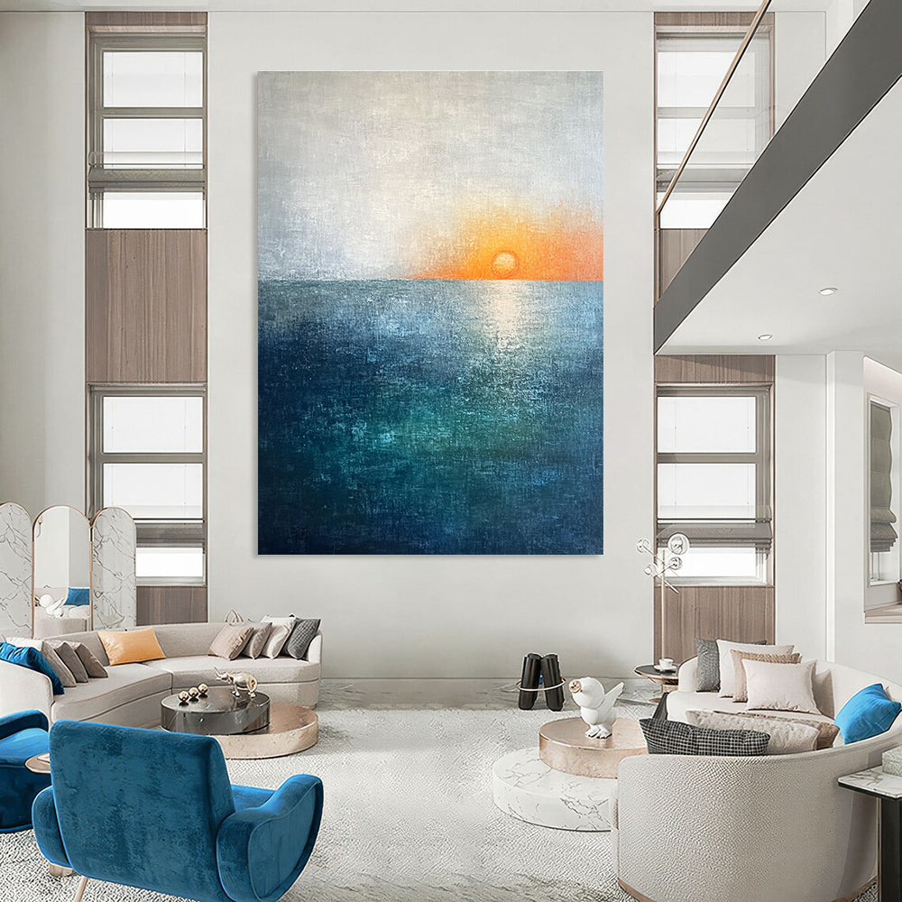 Large abstract painting featuring a soft sky blue and teal gradient with a grey expanse and a small orange sun setting on the horizon.STSC094