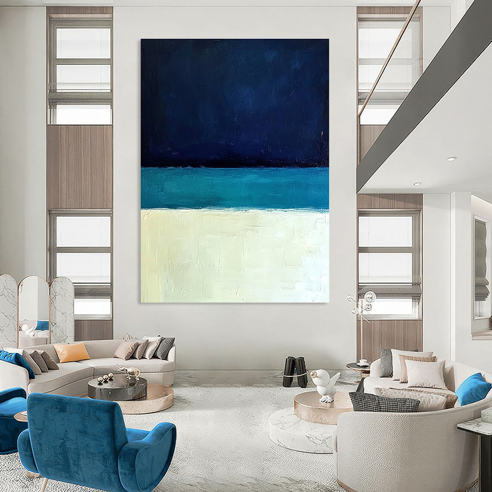 Large abstract painting featuring a minimalist ocean scene with blue tones white sand beach and a dark sky in Rothko style.STSC884