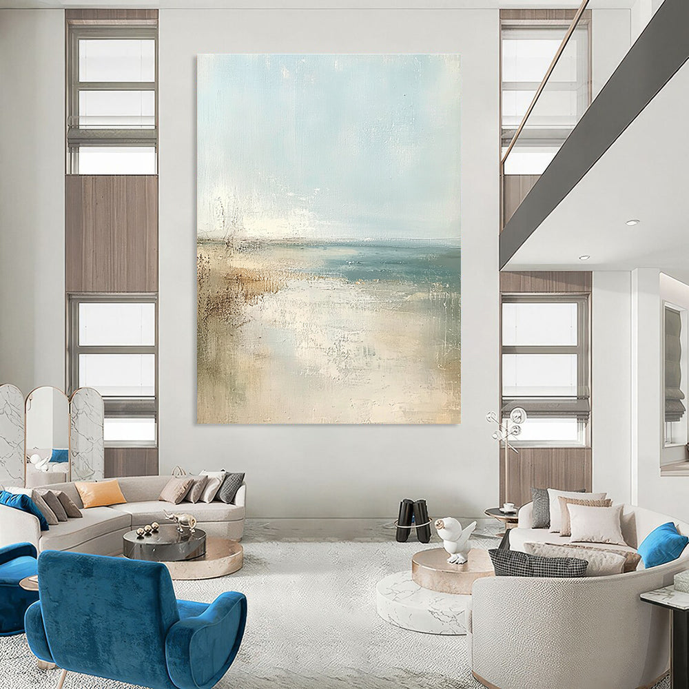 Large abstract painting of a beach in soft pastel colors featuring a light blue sky and neutral tones for a serene atmosphere.STSC158