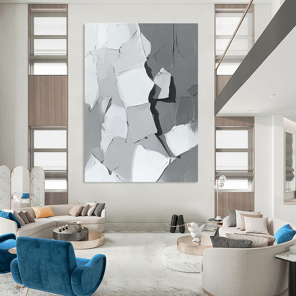 Large abstract painting in gray and white showcasing body parts in armor with bold brush strokes and thick paint application in a striking monochrome palette.STSC479
