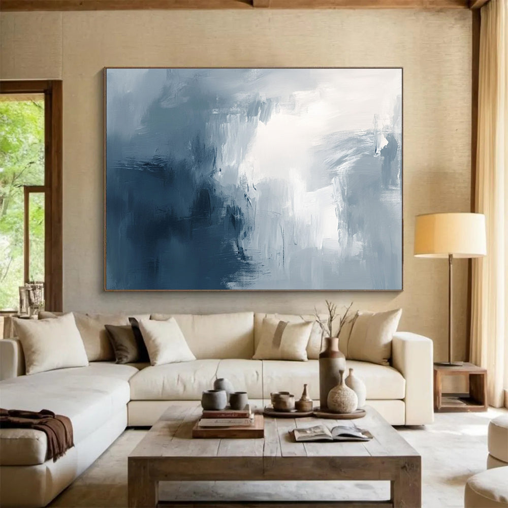 Large abstract painting with broad brush strokes in gray white and navy blue evoking calmness and introspection through soft gradients.SC048