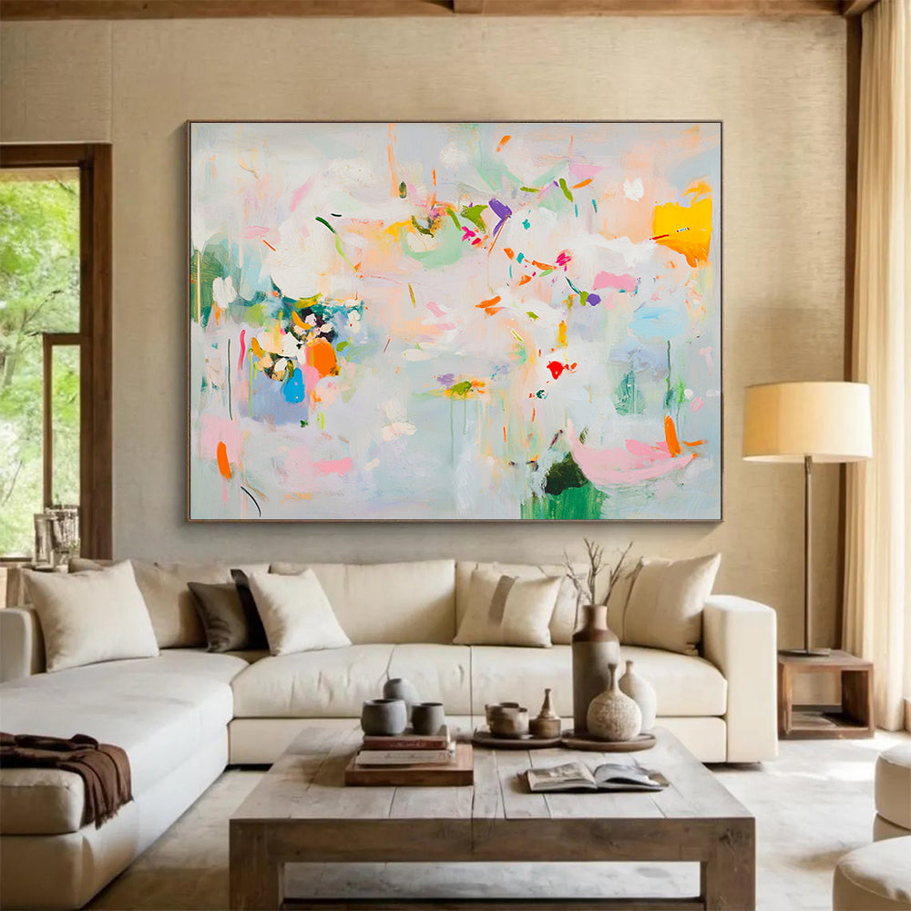 Large abstract painting in soft pastels featuring spring themes with flowers leaves trees and vibrant splashes of color creating a lively atmosphere.SC384