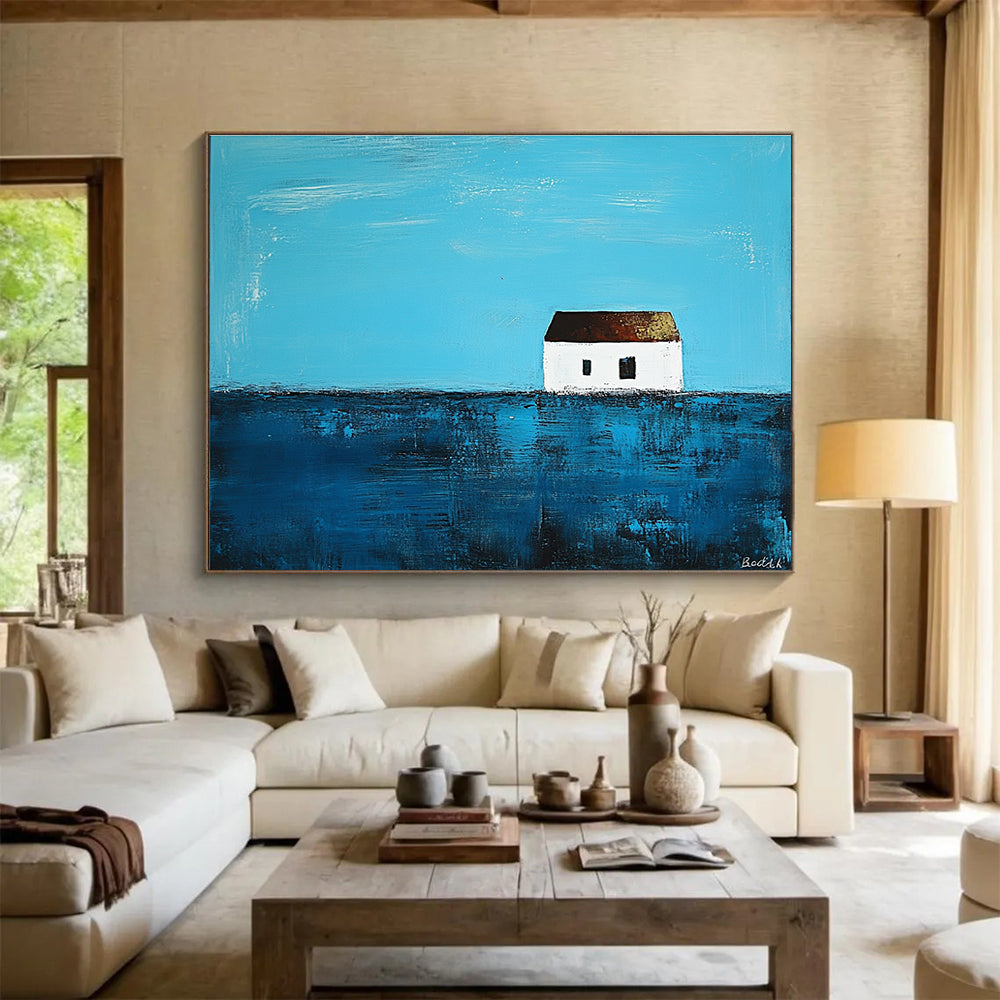 A large abstract painting featuring a small white house on the horizon surrounded by deep blue sea in the style of Anna Bocek.SC553
