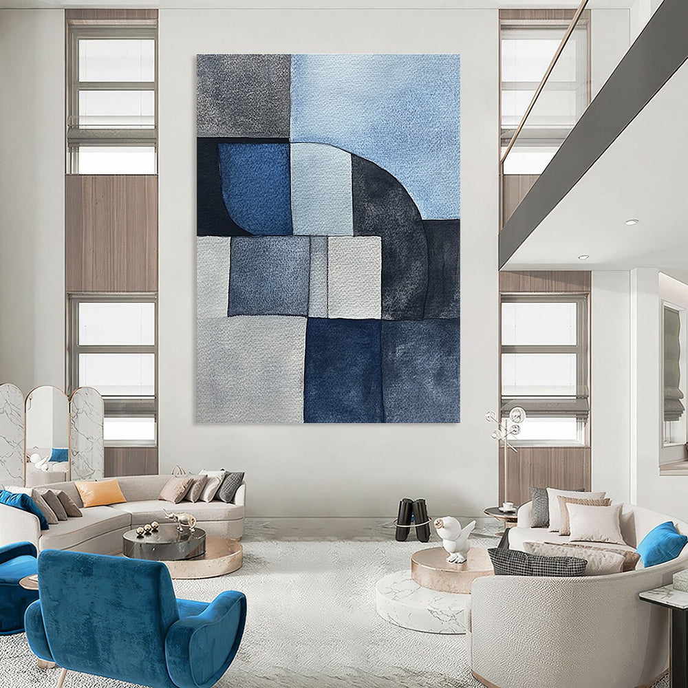 Large abstract painting features minimalistic gray-blue watercolor cubist shapes depicting sandstone rocks in a serene desert landscape.STSC240