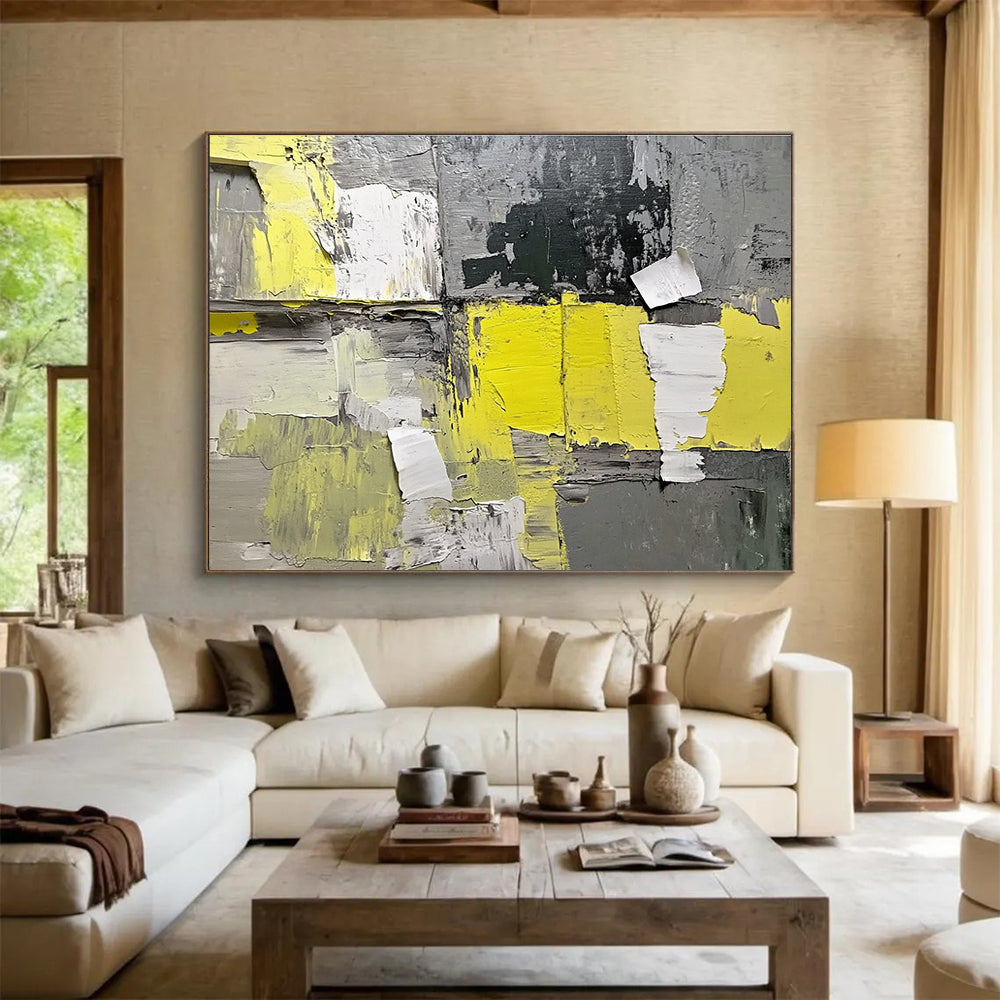 Large abstract painting featuring gray and yellow hues with textured paper elements extending from the wall for added dimension.SC240