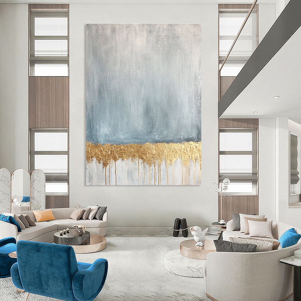 Large abstract painting featuring a textured pale blue and gold palette with a gold metallic foil line across a soft grey and white background.STSC571