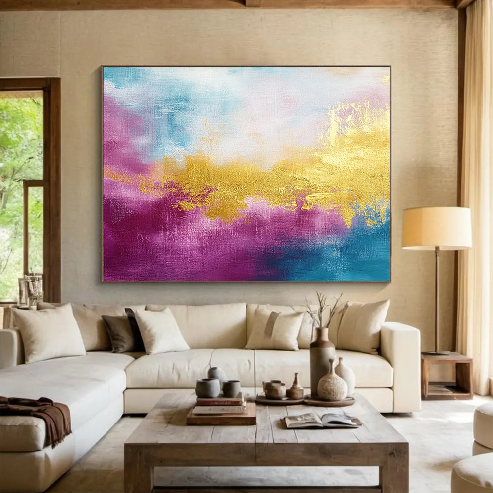 A large abstract painting features gold, magenta, and cyan hues with soft brush strokes and a tranquil water-inspired backdrop.SC322