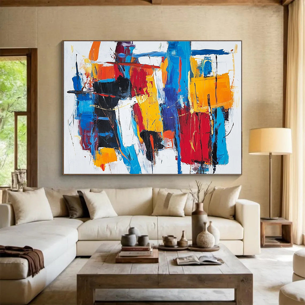 Large abstract painting with thick brush strokes and vibrant reds blues and yellows creating a unique abstract cityscape on a white background.SC262