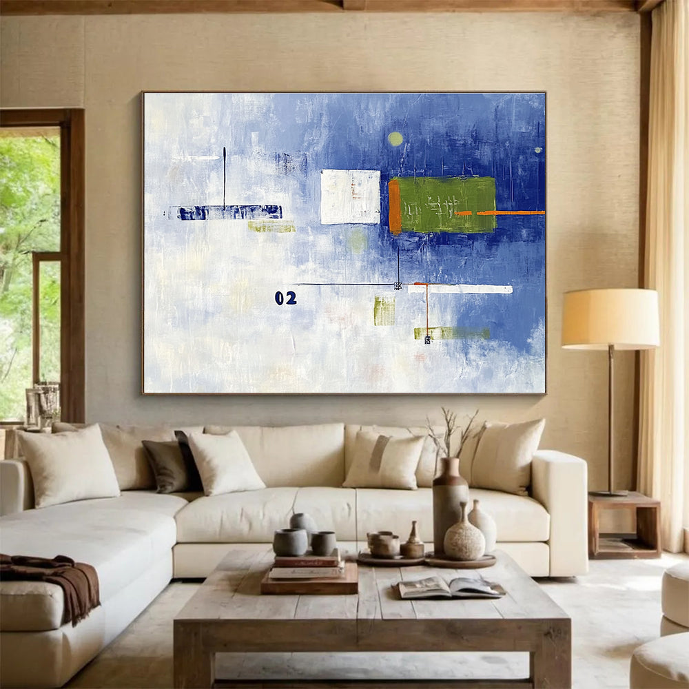 A large abstract painting with broad brush strokes in cool blue and white, featuring bold geometric shapes in green and orange, creating depth and contrast.SC493