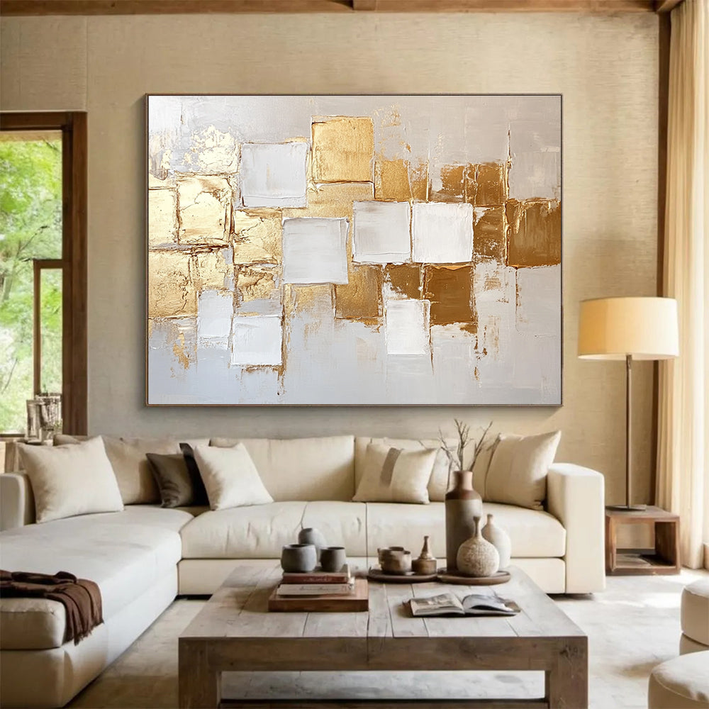 Large abstract painting in white and gold featuring textured square block patterns and soft lighting for an elegant touch.SC292