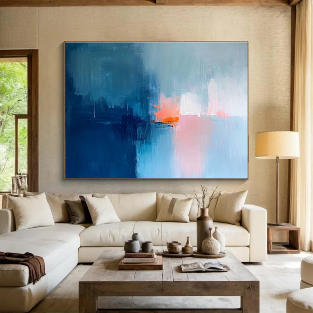 Large abstract painting in soft blue tones with pink and orange accents creates a serene mood through expressive brush strokes and blurred edges.SC253