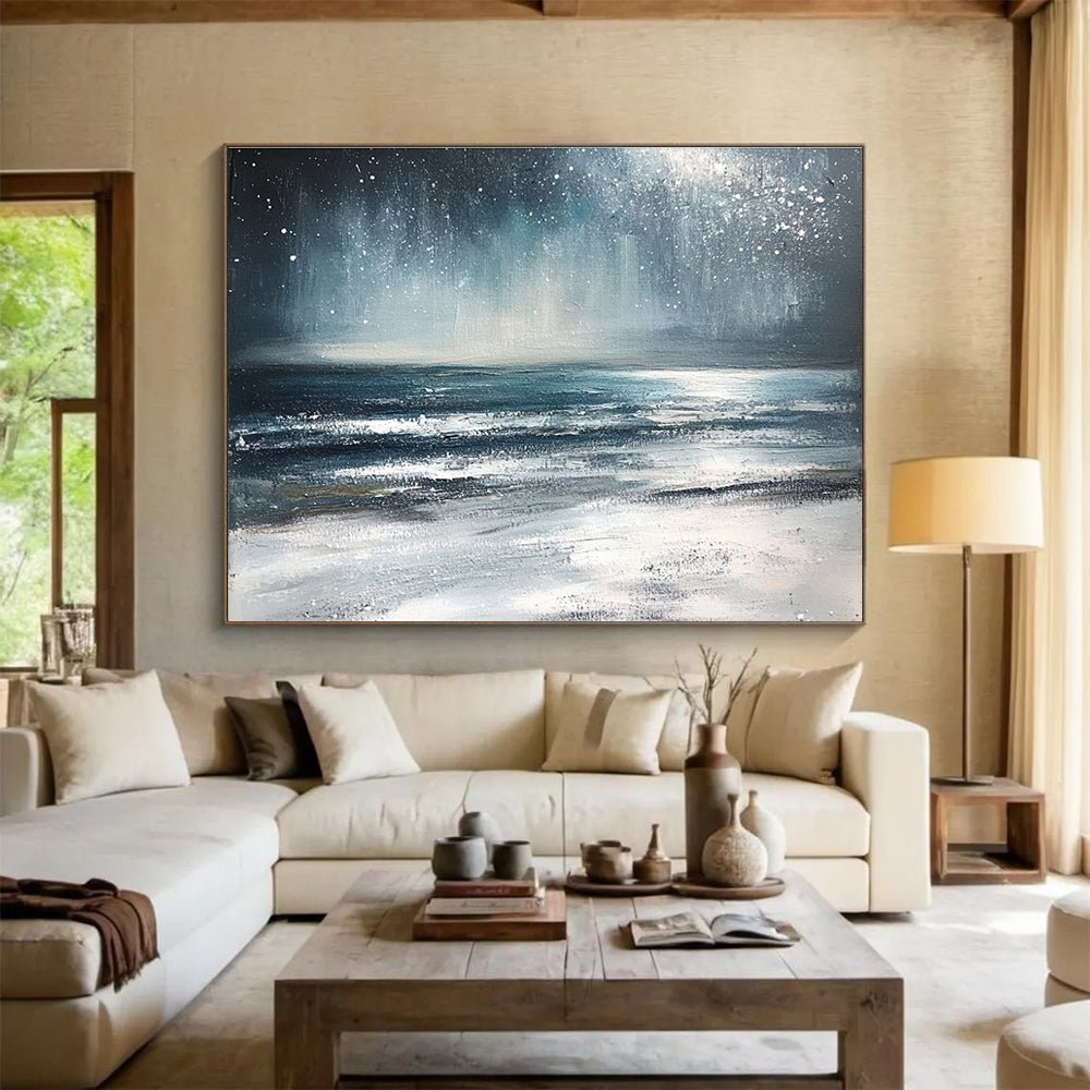 Large abstract painting depicting a winter ocean scene with dark blue and gray tones a starry white sky and sandy beach resembling snow.SC412