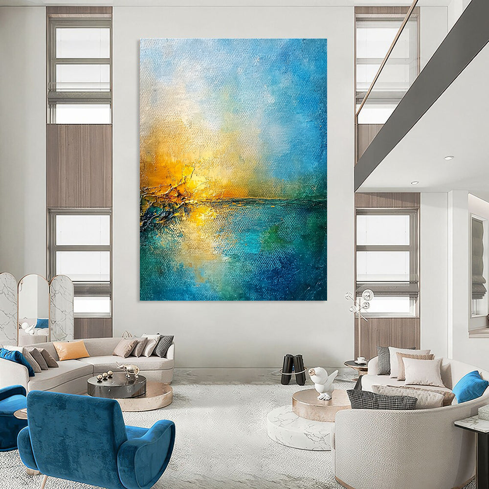 Large abstract painting of a golden sunset over a blue sea featuring textured canvas and rustic-core style nature-inspired colors.STSC165