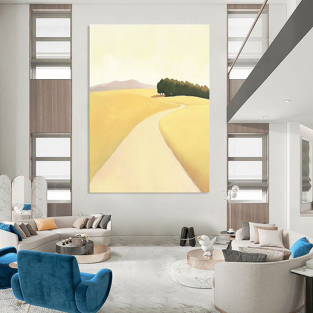 A large abstract painting depicting a minimalist road in an open field with hills and trees in soft yellow beige and green tones.STSC1167