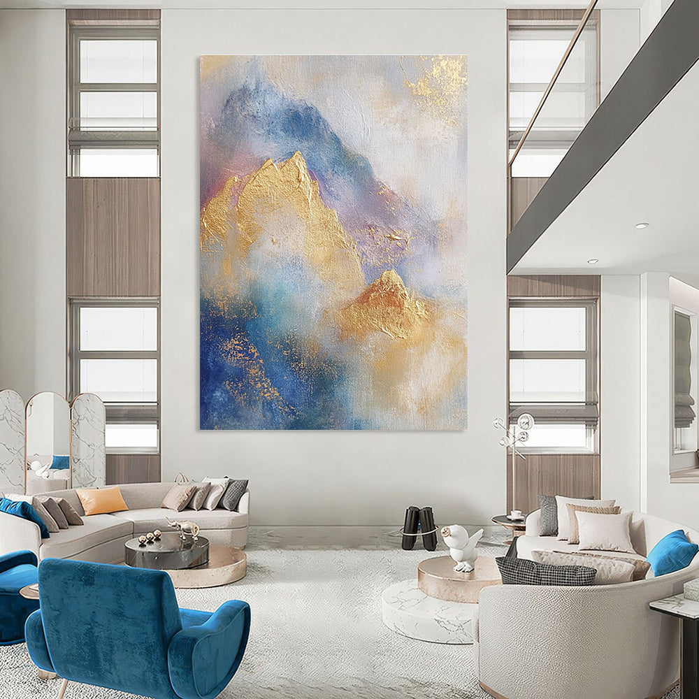 Large abstract painting featuring soft blue and gold tones with gilded mountains and textured brushstrokes for a striking visual impact.STSC446