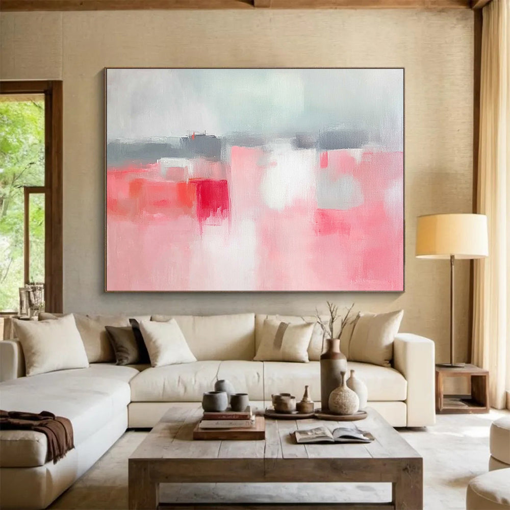 Large abstract painting featuring soft pink and grey tones, white space, sky blue, red accents, and a blurred town background.SC257