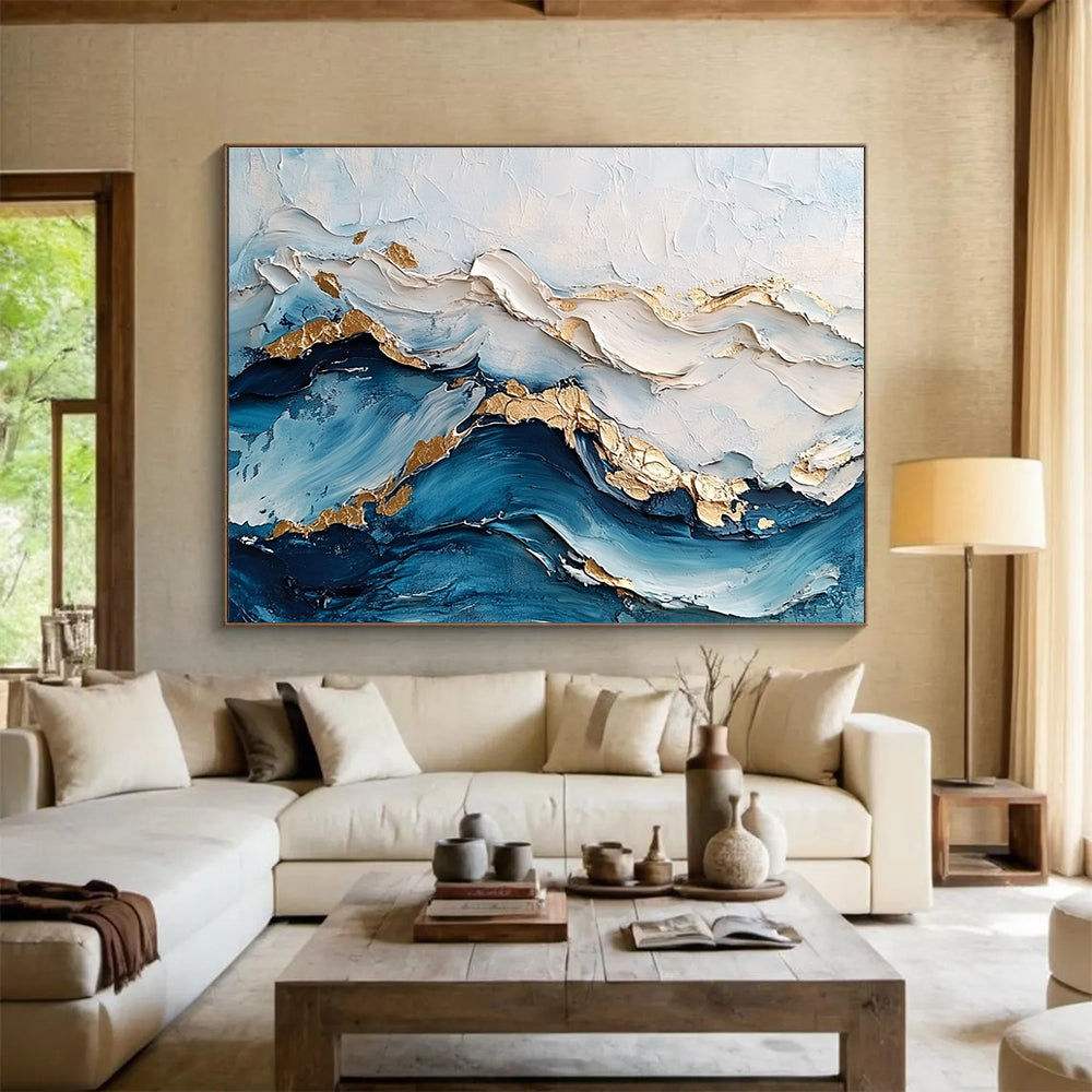 Large abstract painting featuring ocean waves in textured white and blue hues with gold accents for depth and elegance.SC102