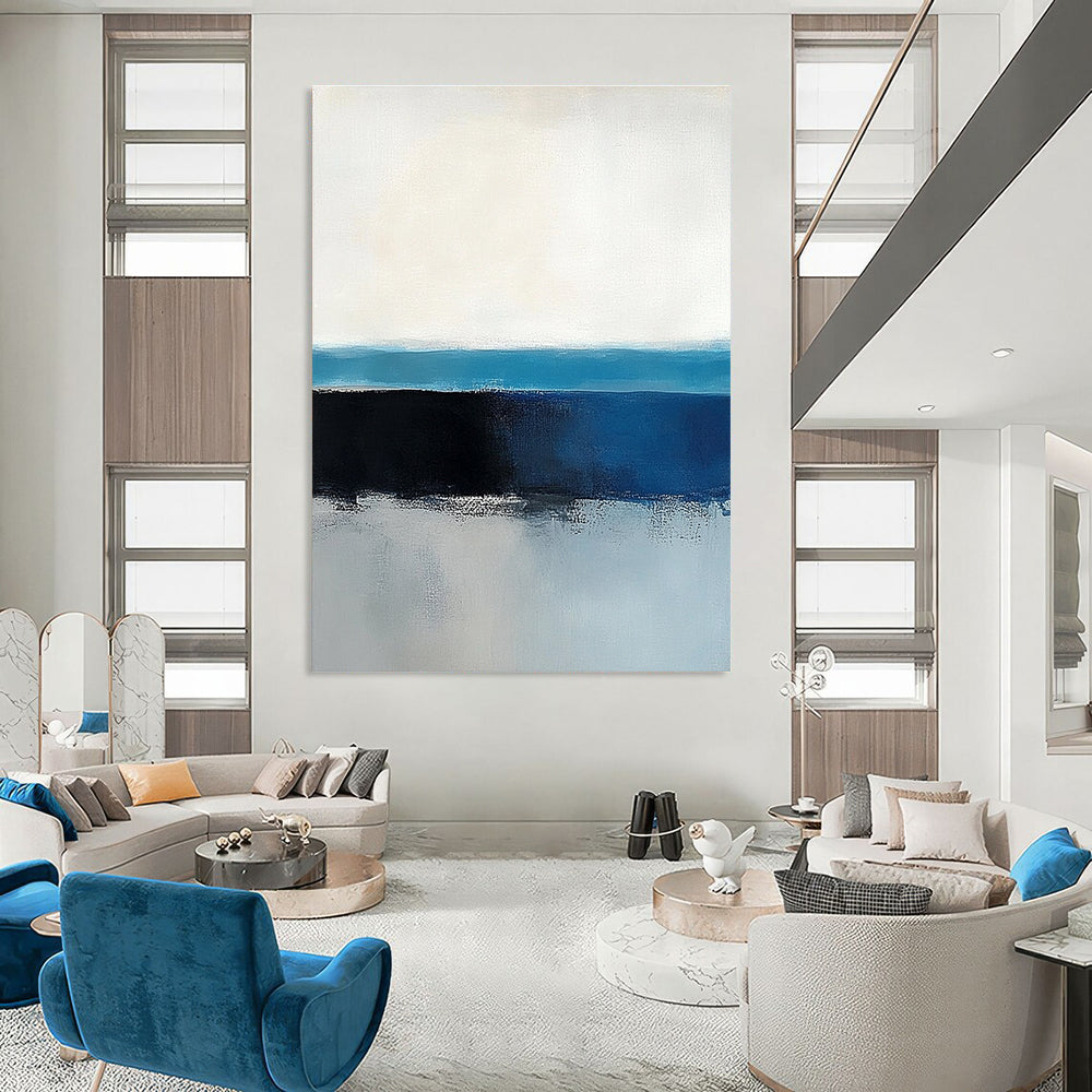 Large abstract painting of the ocean horizon featuring blue and gray tones in a minimalist style with neutral colors.STSC342