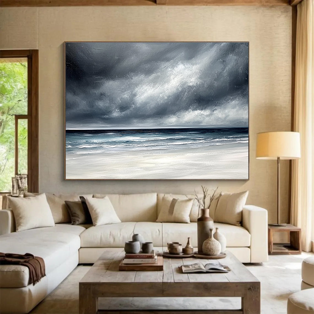 Large abstract painting featuring an ocean with stormy gray clouds and a white sand beach in soft gray and blue tones.SC163