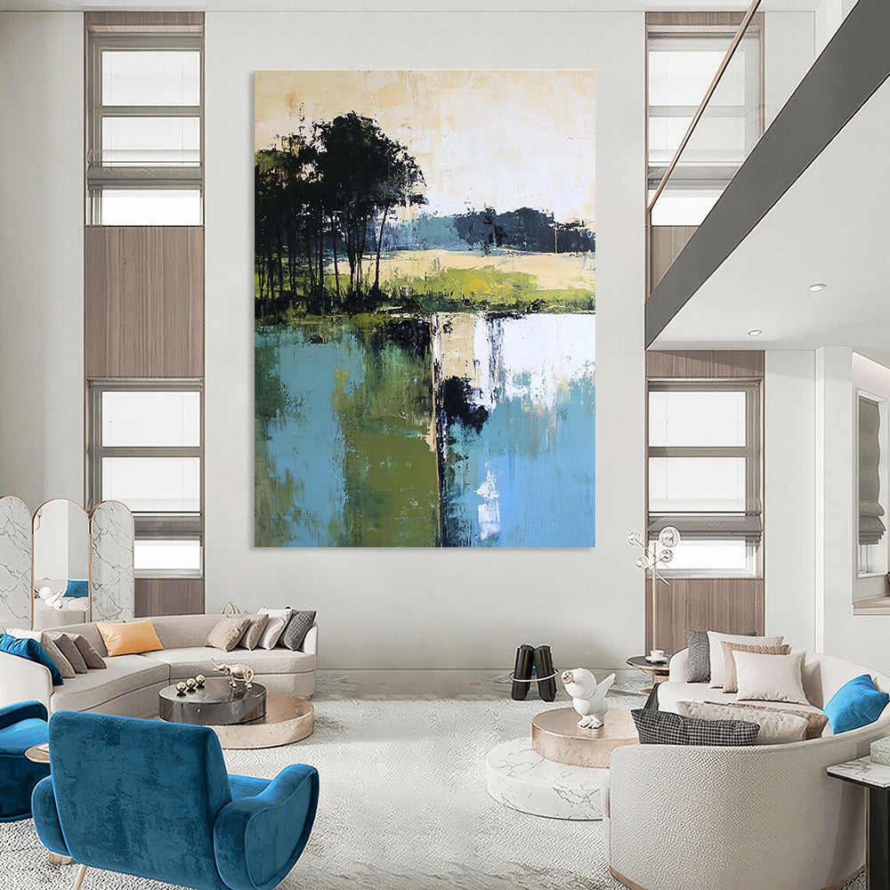 Large abstract painting featuring green blue and beige hues with distant trees foreground trees and green grass by the water.STSC098