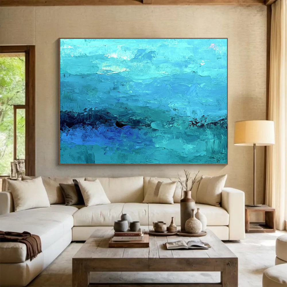 Large abstract painting of the ocean in soft blues and teals showcasing impressionistic waves and a mysterious silhouette beneath gentle mist.SC201