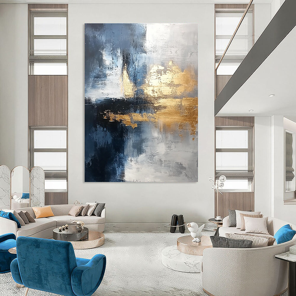 Large abstract painting blending silver and gold with gray blue tones and light brushstrokes featuring exquisite details and a unique composition for a calming atmosphere.STSC376