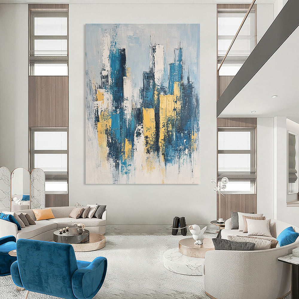 Large abstract painting featuring a modern cityscape in neutral blue and gray tones with yellow accents inspired by impressionist style.STSC1358