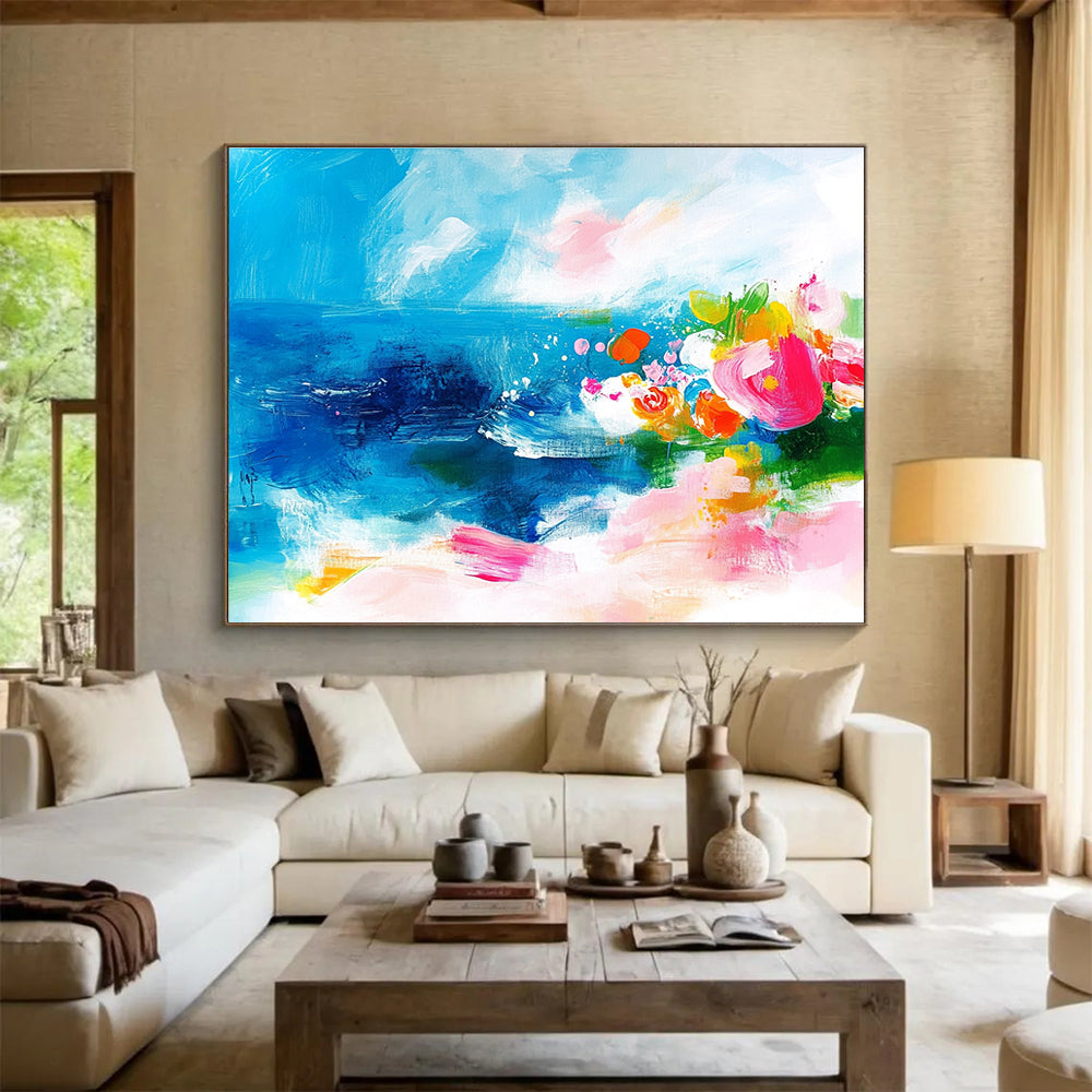 Large abstract painting of the ocean featuring bold brush strokes in pink blue green and orange with small flowers on a textured white background.SC363