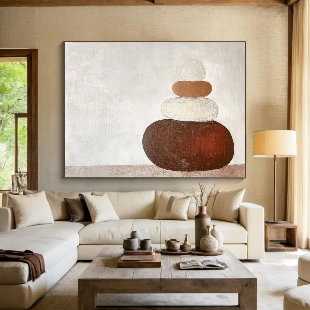 Large abstract painting in earth tones featuring three stacked rocks against a white background creating an elegant contrast.SC495
