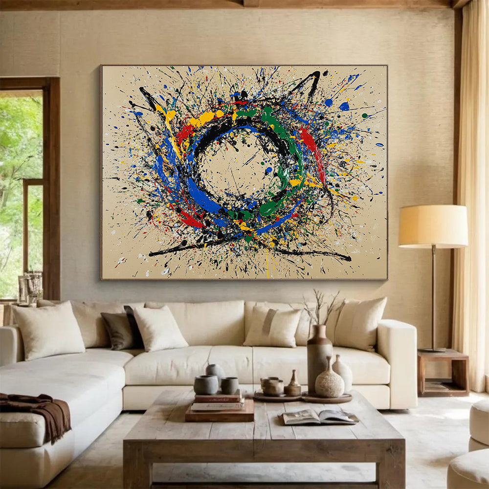 A large abstract painting featuring a circular splash pattern in blue red green yellow and black on a beige background.SC331