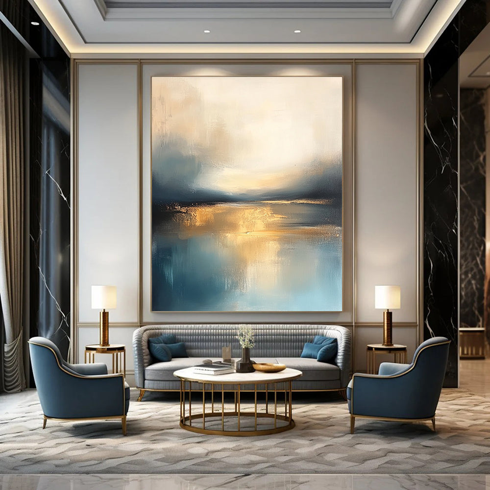 Large abstract painting featuring soft blue and gold tones with a calm sea reflections dramatic clouds and a tranquil sky.STSC103