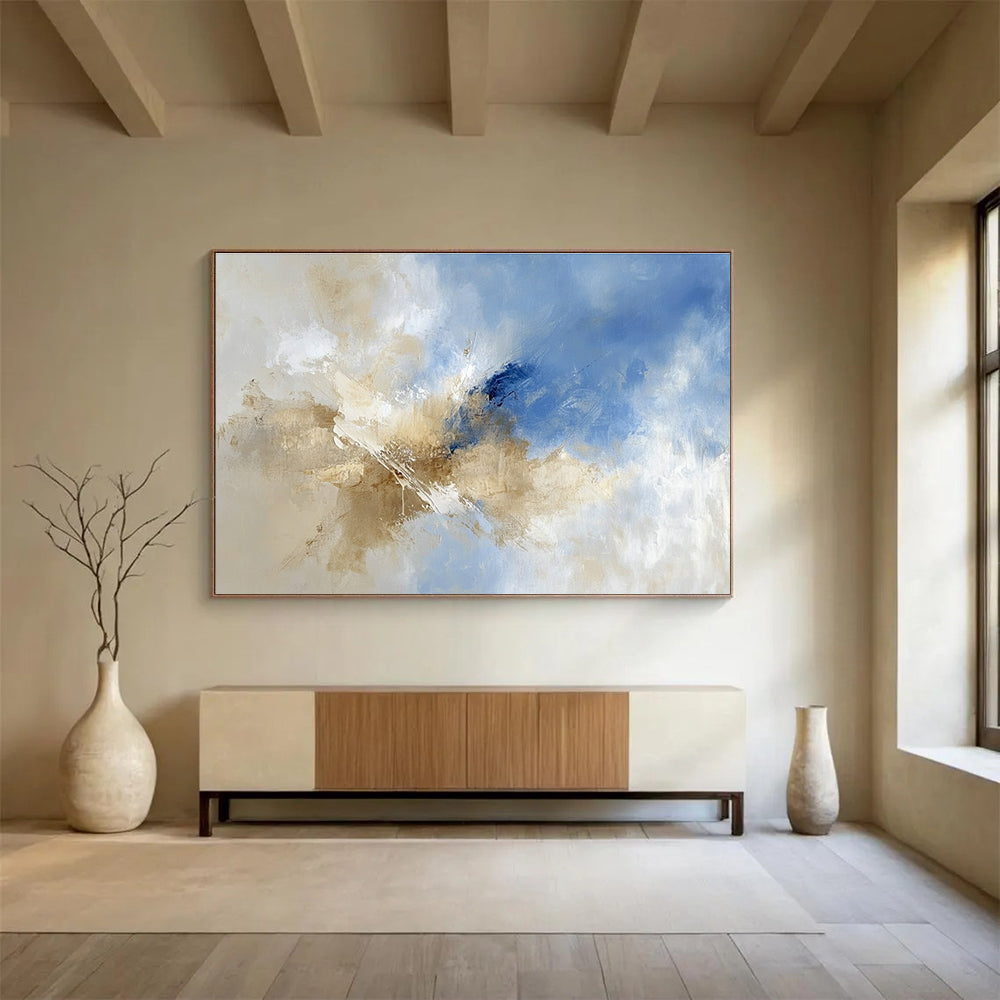 Large abstract painting featuring blue and beige hues with clouds in the sky, blending earthy tones of brown for a serene atmosphere.SC020