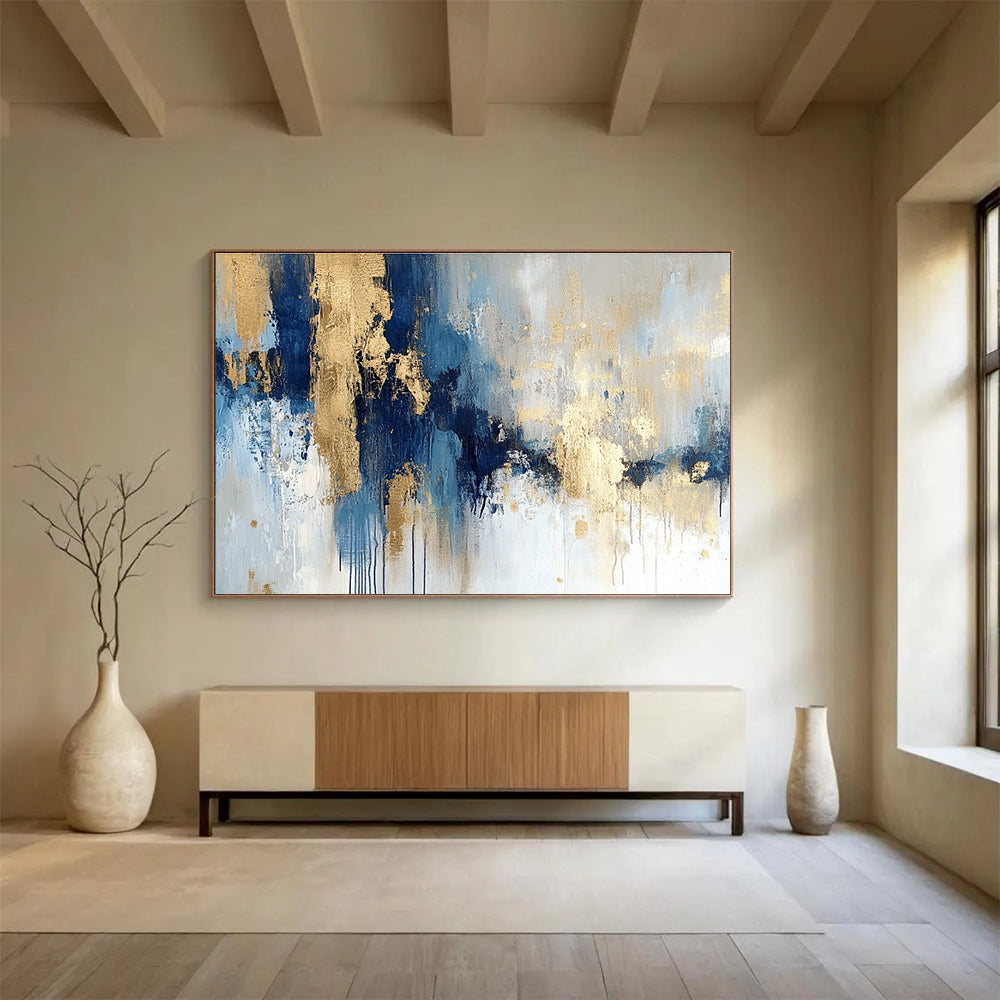 Large abstract painting in blue and gold with soft edges and texture featuring modern elegance and movement on a white background.SC021